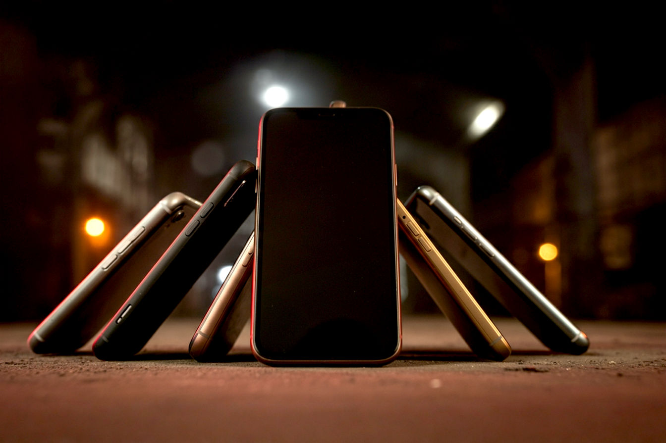 a group of seven tough looking smarthphones on an industrial background with moody lighting that makes this professional photograph seem epic